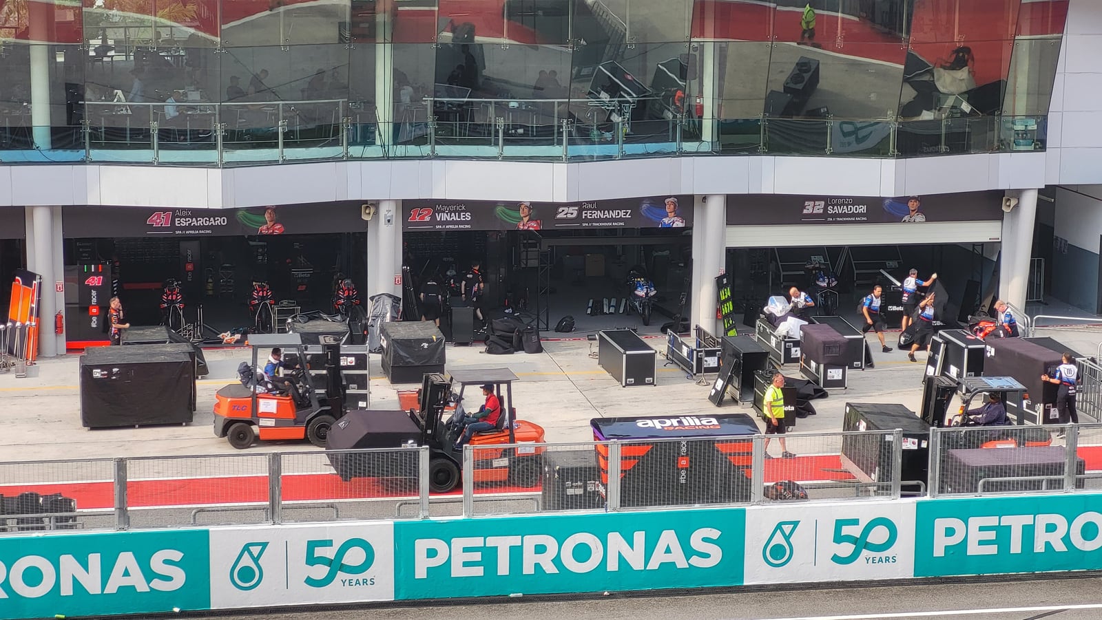 As boxes da Aprilia no pit lane de Sepang, com os nomes dos pilotos por cima